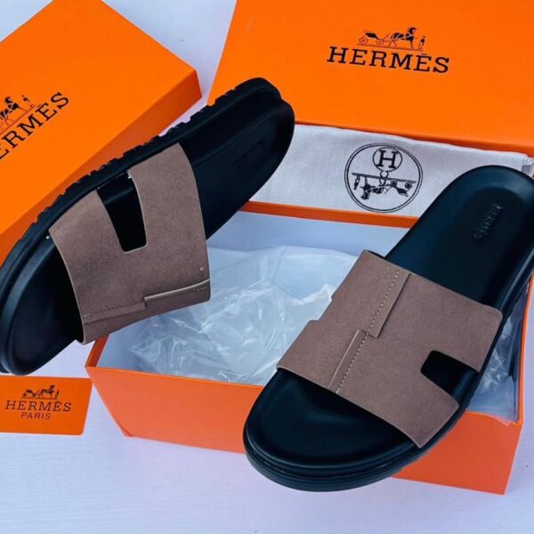 These Hermes brown and black H cut out strap slide sandals combine timeless elegance with contemporary luxury. Featuring the iconic H inspired strap design and a refined silhouette these sandals offer a sophisticated look for modern casual styling.